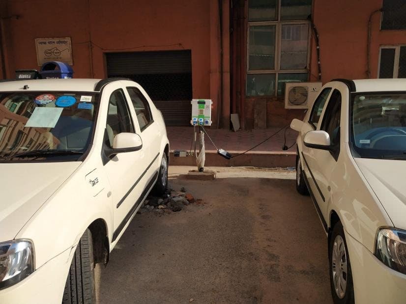 EVIT charger between two government electric cars in a parking bay
